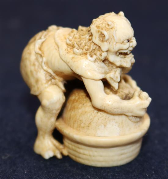 A Japanese ivory netsuke of an oni leaning on a cooking cauldron for rice, signed Tomomasa, 19th century, 4cm, loss to one toe